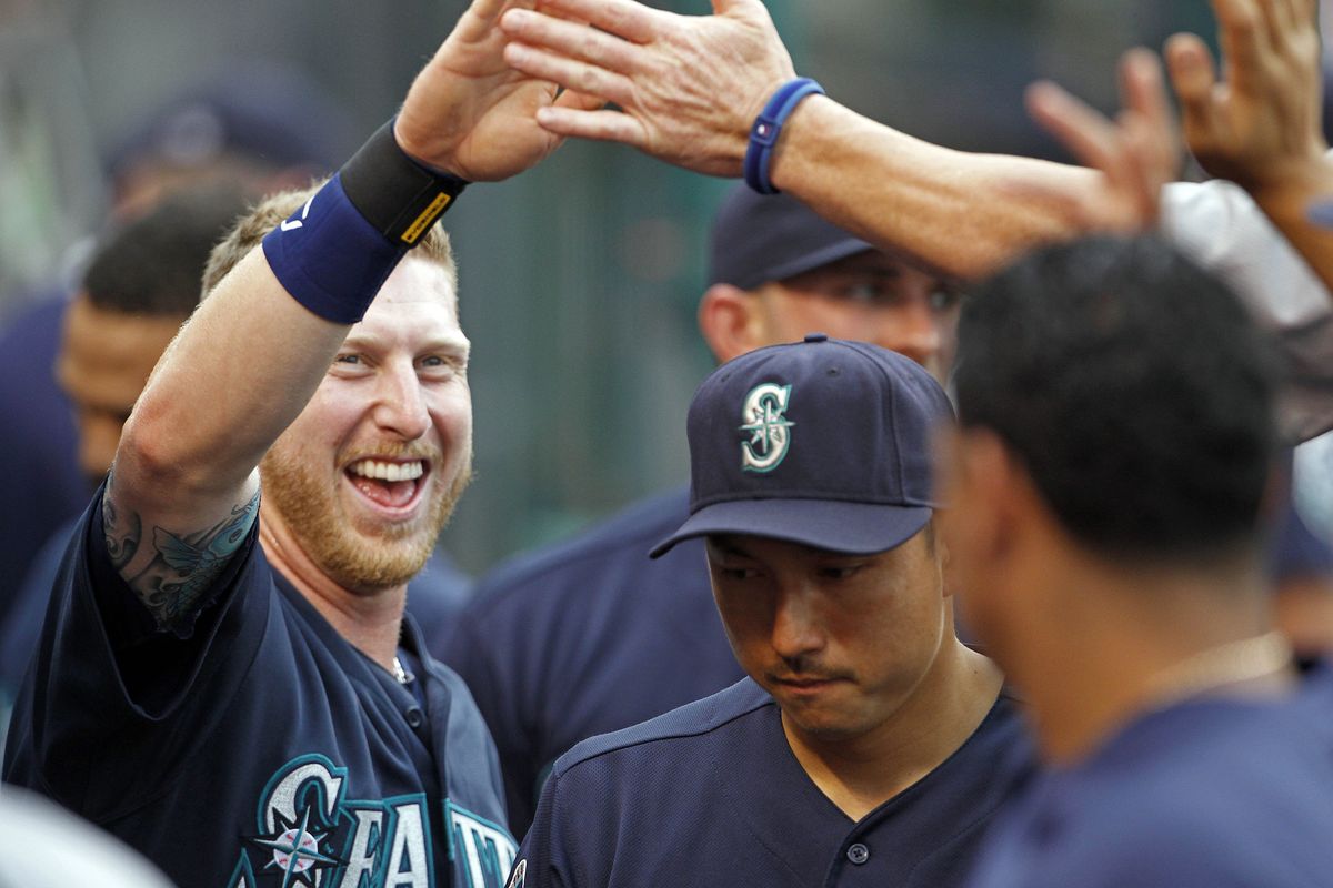 Mariners’ Mike Carp celebrates after scoring on Trayvon Robinson’s single in the second. (Associated Press)