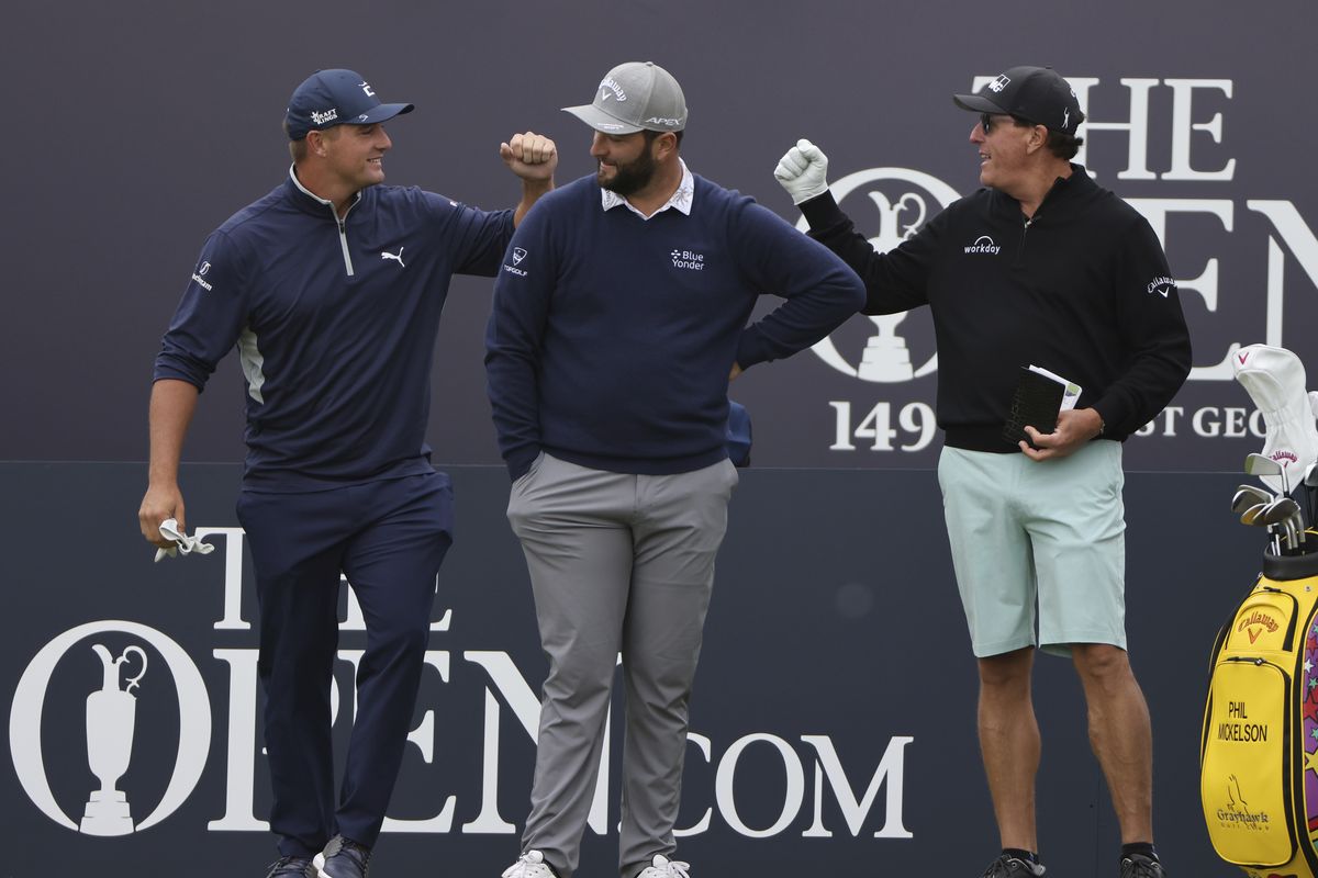 United States' Bryson DeChambeau, left, greets United States' Phil Mickelson, right behind Spain's Jon Rahm as they wait to play on the 1st tee during a practice round for the British Open Golf Championship at Royal St George's golf course Sandwich, England, Wednesday, July 14, 2021. The Open starts Thursday, July, 15.  (Ian Walton)