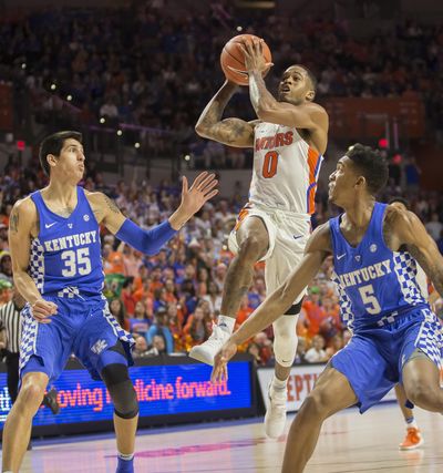 Florida guard Kasey Hill (0) drives to the basket between Kentucky forward Derek Willis (35) and Kentucky guard Malik Monk (5) during the first half of an NCAA college basketball game in Gainesville, Fla., Saturday, Feb. 4, 2017. (Ron Irby / Associated Press)
