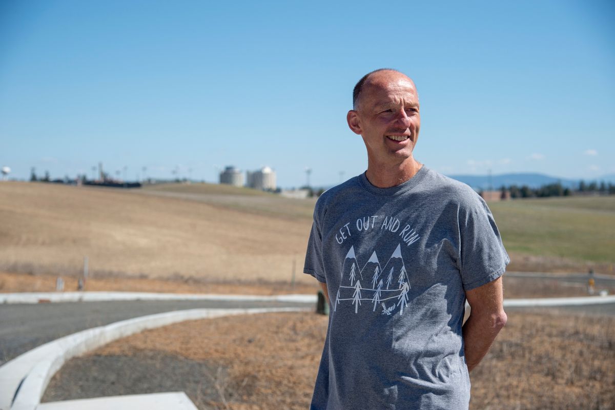 Dave Cook, the longtime Sports Information Director at Eastern Washington University, stands on the unpaved back road near EWU on April 21, 2020.  (JESSE TINSLEY)