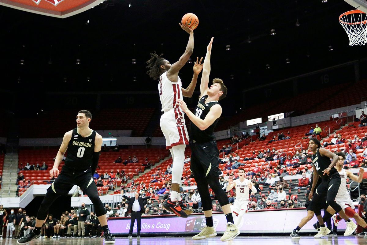 Washington State forward Efe Abogidi, left, shoots over Colorado forward Will Loughlin on Sunday in Pullman. The Cougars won 70-43.  (Young Kwak)