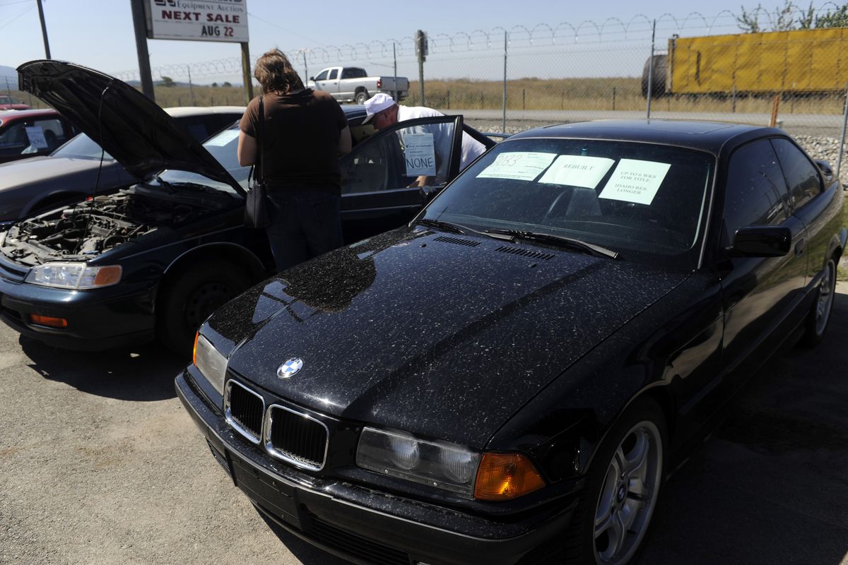 A seized 1994 BMW, right, awaits auction at Reinland Auction Co. on Aug. 21. (Jesse Tinsley / The Spokesman-Review)