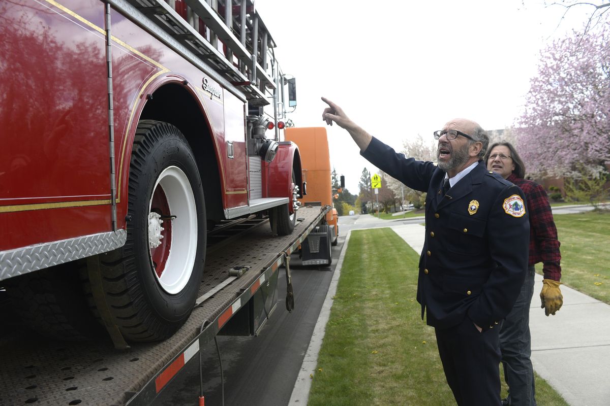 Fire Department Chaplain Ron Baer points out how he tied down the ladders on his 1965 Seagrave firetruck to trucker David Prokuski, right, as the truck is being Monday for the trip to Pennsylvania. (Jesse Tinsley)