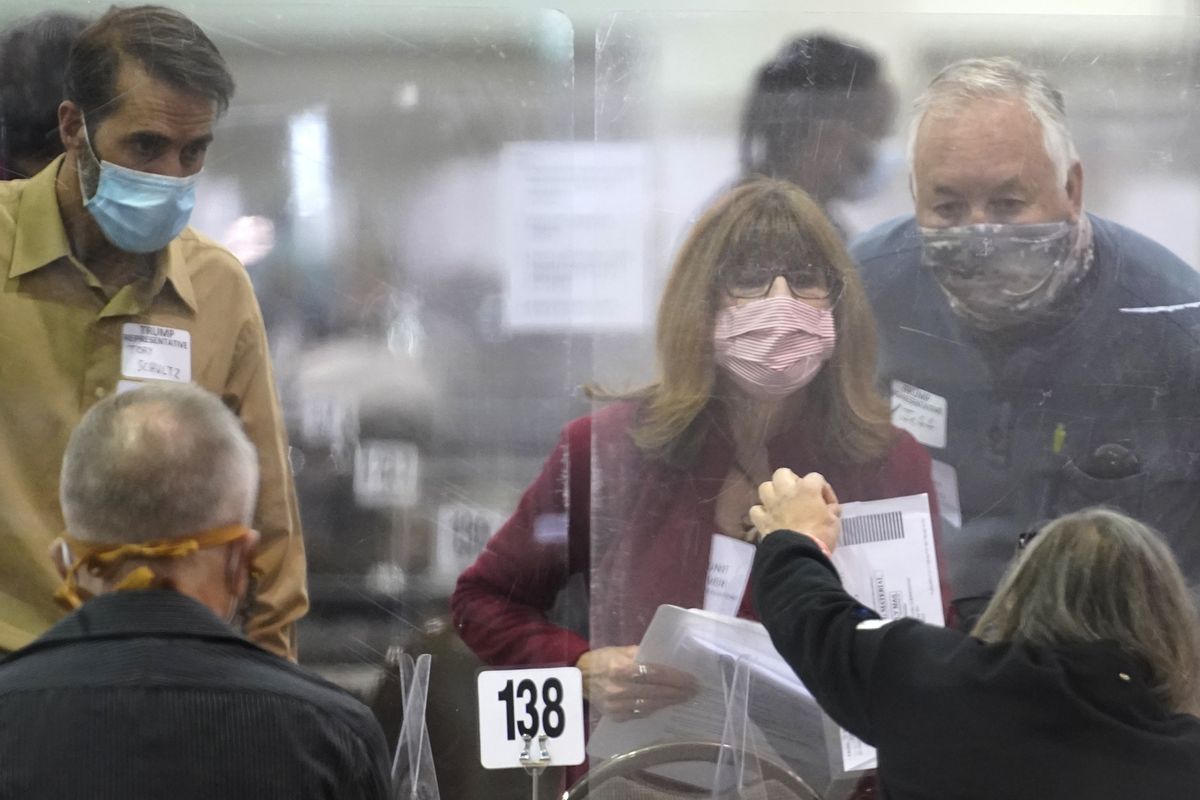 FILE - In this Nov. 20, 2020, file photo, recount observers check ballots during a Milwaukee hand recount of presidential votes at the Wisconsin Center, in Milwaukee, Wis. A narrowly divided Wisconsin Supreme Court on Monday, Dec. 14, 2020, rejected President Donald Trump