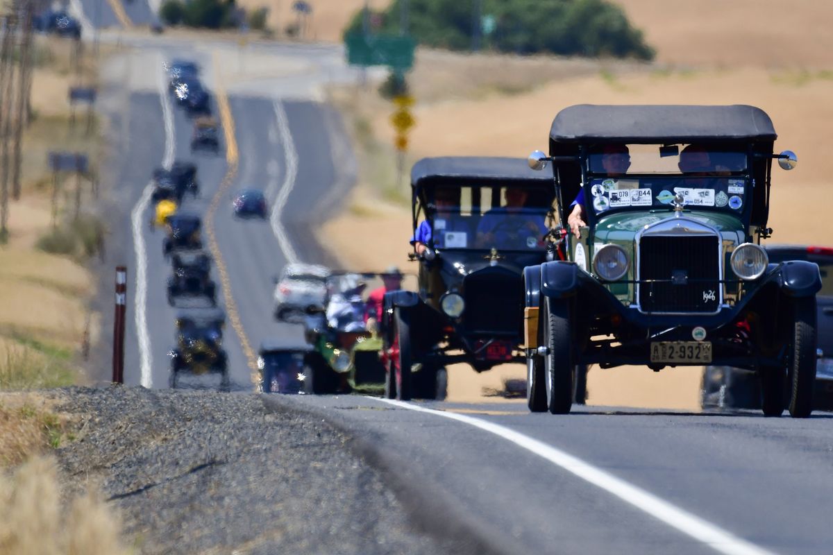 The Model T Ford Club of America rolls through rippling heatwaves as they drive Highway 206 on Monday, July 12, 2021, in Mead, Wash.  (Tyler Tjomsland/The Spokesman-Review)