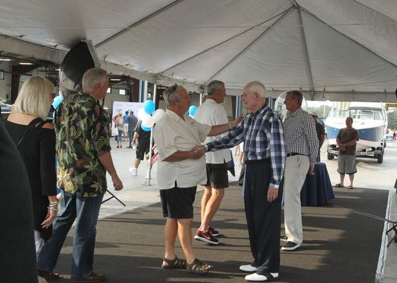 Gary Greenleaf of Coeur d'Alene gives Duane Hagadone a friendly pat on the arm as they say hello Saturday evening at the entrance of the Hagadone Marine Grand Opening Celebration. Hagadone greeted each guest with a smile and a handshake. (Devin Heilman/PressP