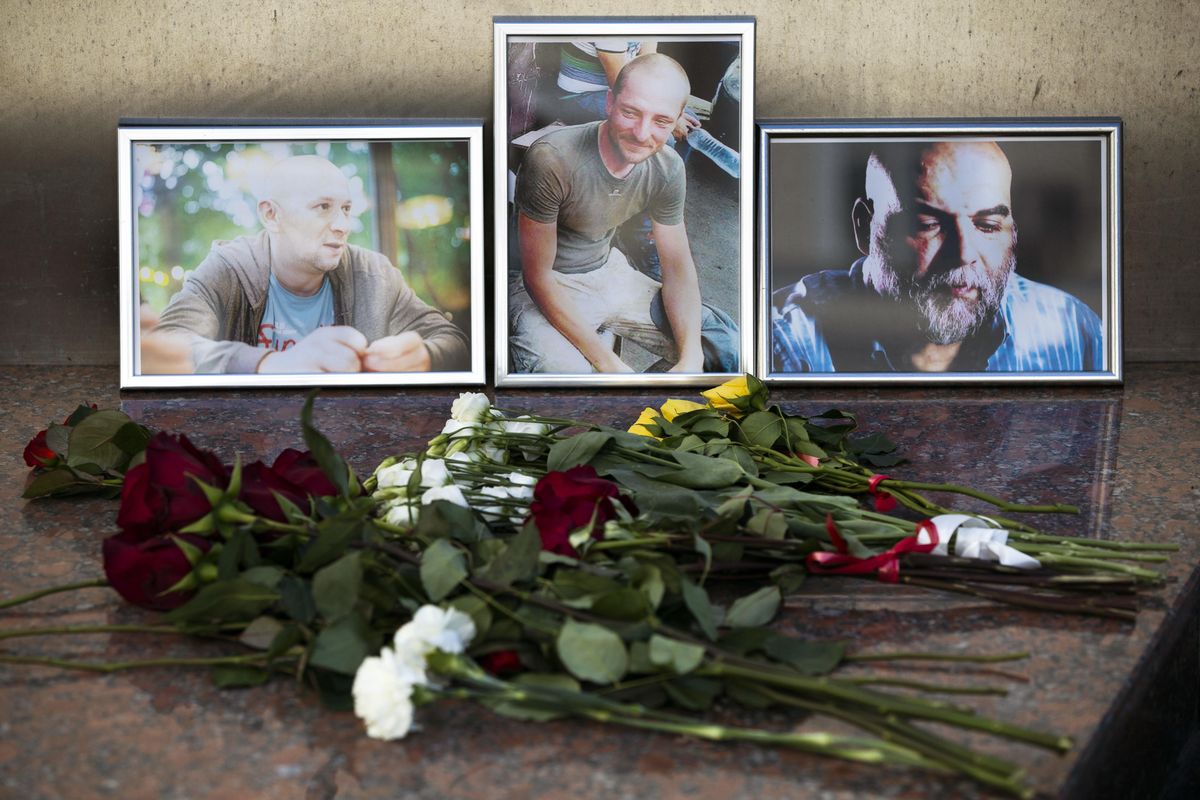 Flowers are placed by portraits of slain journalists Alexander Rastorguyev, Kirill Radchenko and Orkhan Dzhemal, at the Russian journalists Union building in Moscow, Russia, Wednesday, Aug. 1, 2018. (Pavel Golovkin / Associated Press)