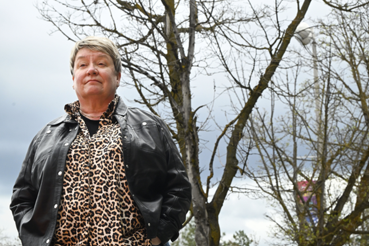 Pia Hallenberg, chair of the Riverside Neighborhood Council, which includes downtown, stands next to dead trees beside Sushi.com in downtown Spokane. The city sent a notice to the Texas-based owner of the property, Pac Operating, last September, but the business did not seek a permit to replace them within the required 30 days.  (COLIN MULVANY/THE SPOKESMAN-REVIEW)