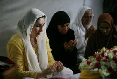 
Former Pakistani Prime Minister Benazir Bhutto, left, prays Sunday with women who lost their husbands in a bomb attack on her procession in Karachi  early Friday. Associated Press
 (Associated Press / The Spokesman-Review)