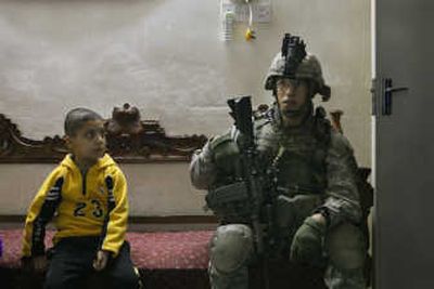 
A boy eyes a US Army soldier during a house search Sunday in the Azamiyah neighborhood of north Baghdad. Associated Press
 (Associated Press / The Spokesman-Review)