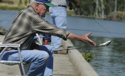 Tom Jones, 77, of Spokane Valley,  tosses a fish back into West Medical Lake on Wednesday. “It’s a nice day if I caught a fish or not,” he said. He caught his first trout moments later and gave it to another angler on the ramp. (Dan Pelle / The Spokesman-Review)