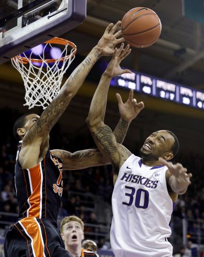 Washington’s Desmond Simmons (30) and Oregon State’s Eric Moreland vie for a rebound during first-half action on Saturday in Seattle. (Associated Press)