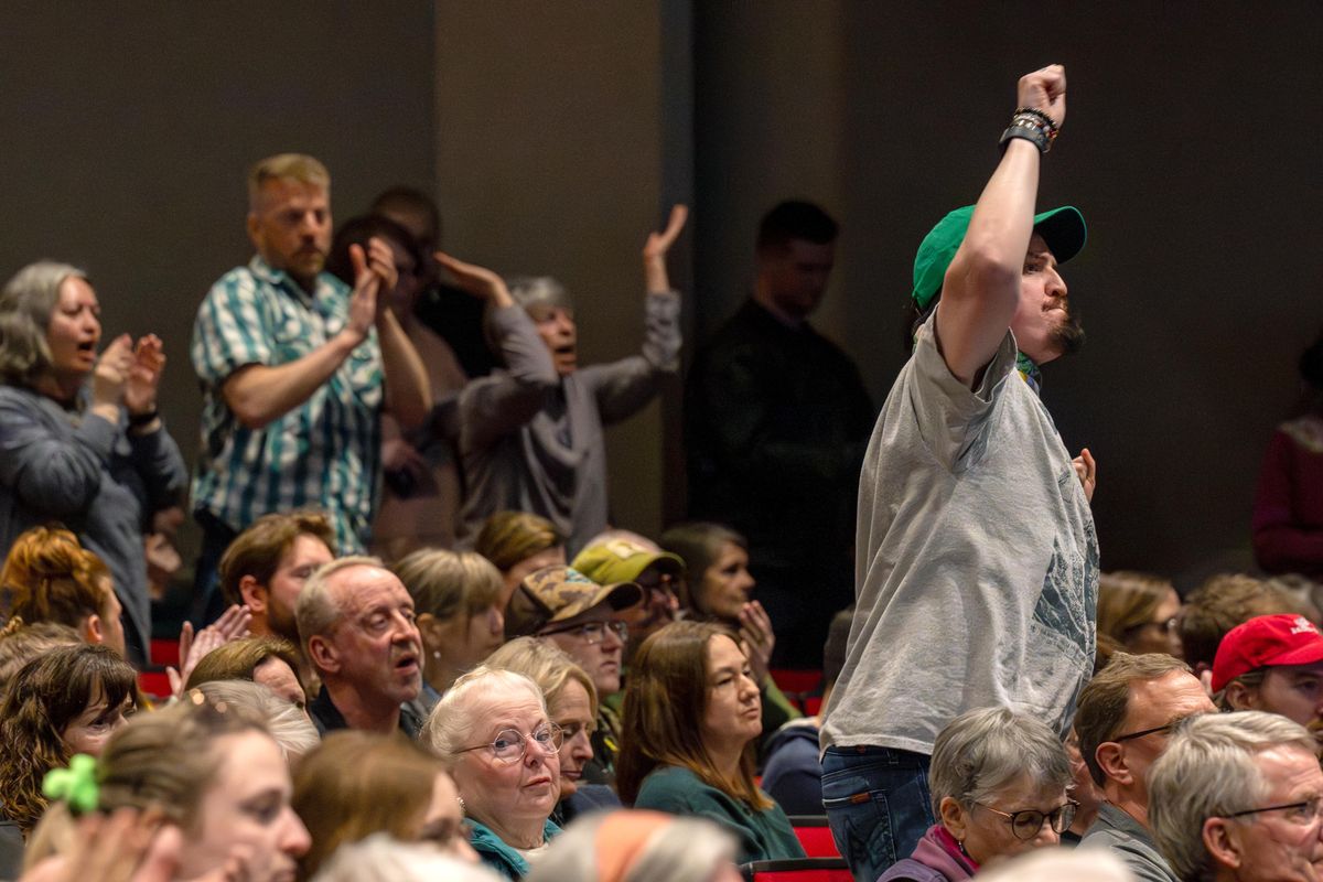 Micah Martinez stands in opposition to how U.S. Rep. Michael Baumgartner answered a refugee’s question during a town hall meeting with his constituents in Washington’s 5th Congressional District on Monday at Whitworth University’s Cowles Auditorium. The event was hosted by Whitworth’s Democracy & Discourse Committee. (COLIN MULVANY)