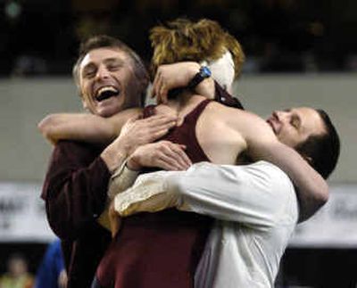 
Cory Fish of University jumps into the arms of his coaches, including head coach Don Owen, left, after winning the State 4A title at 119 pounds in the Tacoma Dome. 
 (Christopher Anderson/ / The Spokesman-Review)