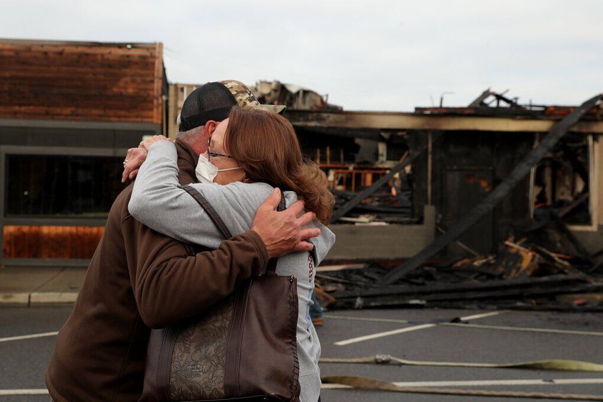 Cheryl McNeil hugs Rick Rovegno, owner of the Locker Room Tavern, after a fire damaged his business in White Center on Monday.   (Erika Schultz / The Seattle Times)