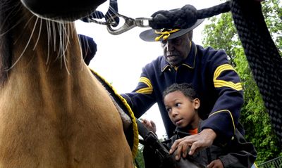 Franklin Moore, 7, of Coeur d’Alene, gets a quick equestrian lesson from Albert Wilkerson Jr., of Athol, on Monday  at the Human Rights Education Institute in Coeur d’Alene in preparation for Juneteenth. Wilkerson will be dressed as a buffalo soldier for the celebration.kathypl@spokesman.com (Kathy Plonka / The Spokesman-Review)