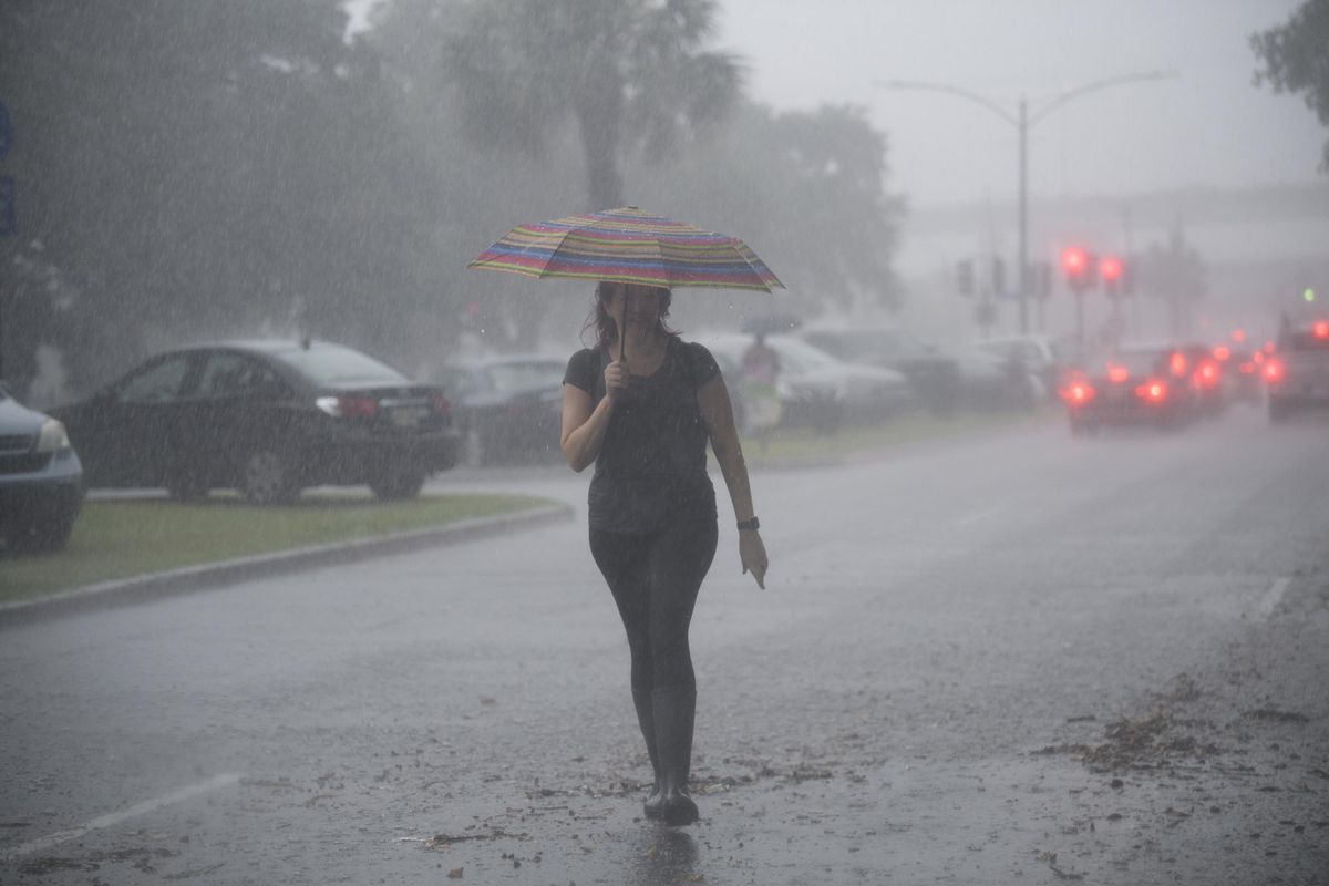A woman walks along S. Carrollton Ave. in New Orleans where cars are parked on the neutral ground to keep from flooding caused by severe thunderstorms, Wednesday, July 10, 2019.A storm swamped streets in New Orleans and prompted a tornado warning near the city Wednesday as concerns grew that even worse weather is on the way to Louisiana and other states along the Gulf of Mexico. (Max Becherer / AP)