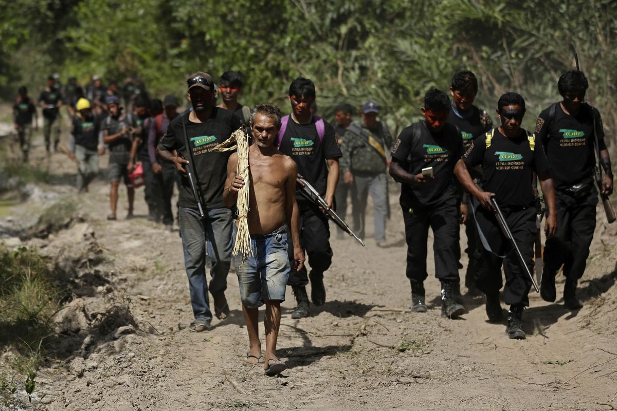 Altemir Freitas Mota carries dry vines, which he said are to make brooms and chairs, as he leads Tenetehara Indigenous men from the Ka