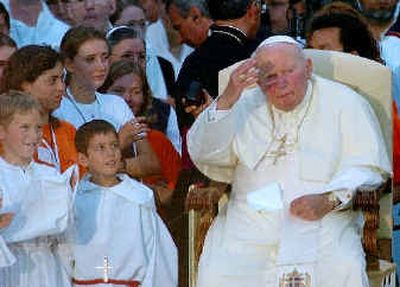
Pope John Paul II, surrounded by children, waves as he sits Saturday in the Immaculate Conception Basilica in Lourdes.
 (Associated Press / The Spokesman-Review)