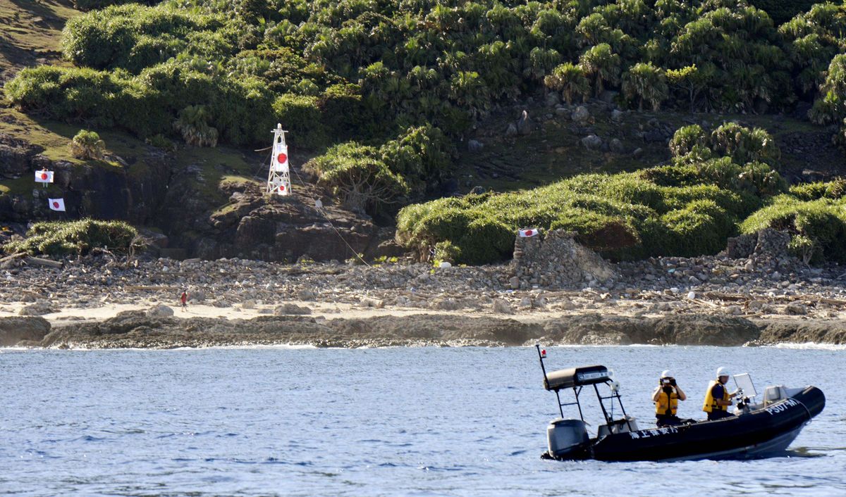 Japan Coast Guard officers patrol on a rubber boat on Sunday as Japanese activists hang national flags in a small archipelago known in Japan as the Senkaku Islands and in China as the Diaoyu Islands. (Associated Press)
