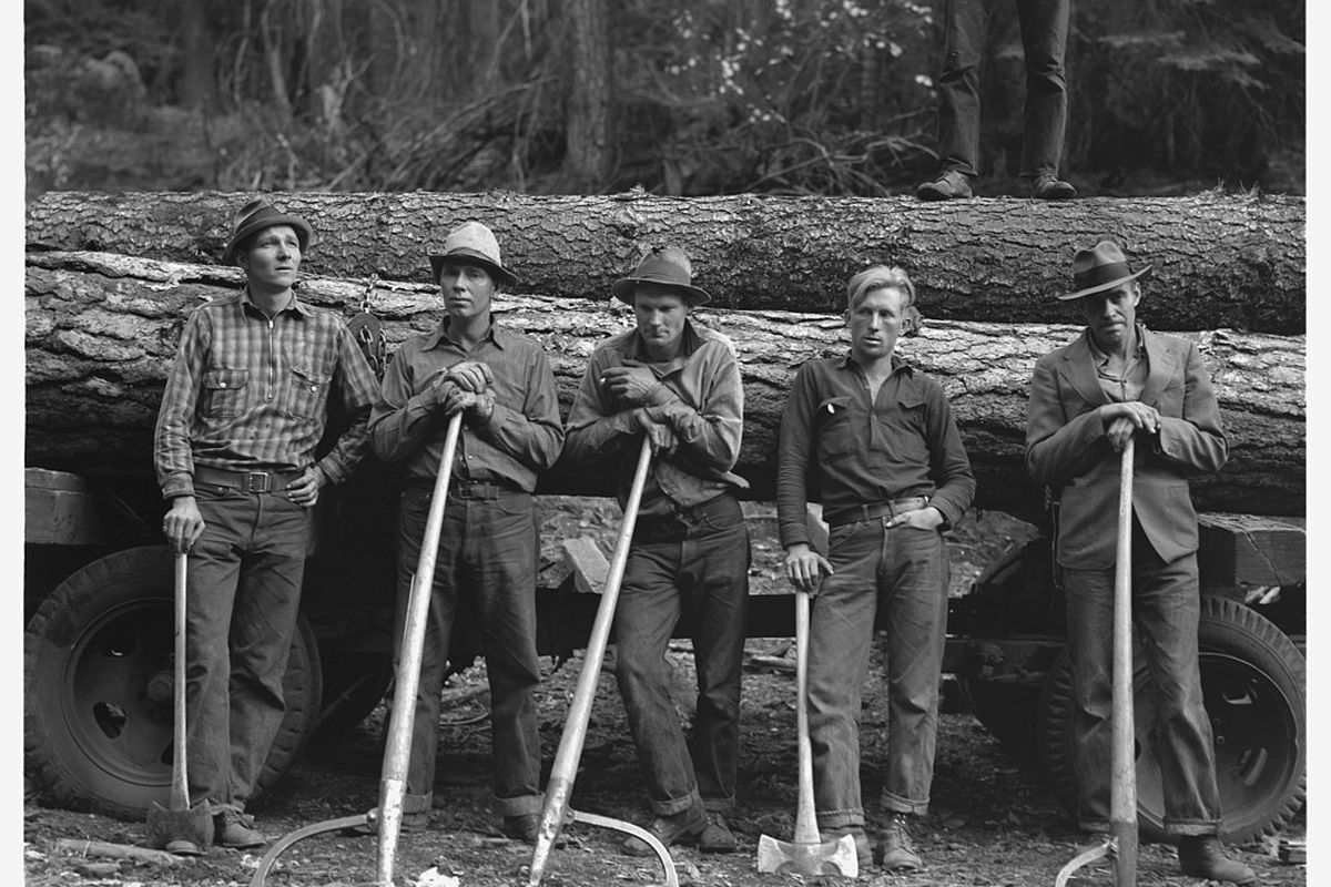 In this October 1939 photo from the Farm Security Administration, five members of the Ola Self-Help Sawmill, from left, Leonard Carlock, Don Holford, Roy Carlock, Richard Michaels and an unidentified man, stand in front of a loaded log truck in northern Gem County, Idaho. Photographer Dorothea Lange was sent to the small community to document the 36-member cooperative that established the mill four years earlier. (Associated Press)