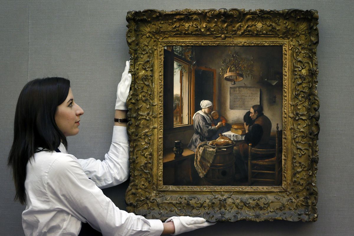 In this Nov. 30, 2012 file photo, a Sotheby’s employee adjusts a painting by Dutch artist Jan Havickszoon Steen called “The Prayer Before the Meal,” during a press viewing before a sale of Old Master Paintings and Drawings, in London. Homes and home life are changing all the time, says Judith Flanders, author of the book, “The Making of Home: The 500-Year Story of How Our Houses Became Our Homes,” who traced the evolution of the house, and concepts of home, in northern Europe and America from the 16th century to the early 20th century. The paintings of the Dutch golden age are heavy with symbolism and appear sparse and sparkling, while the actual homes were crowded with furniture.