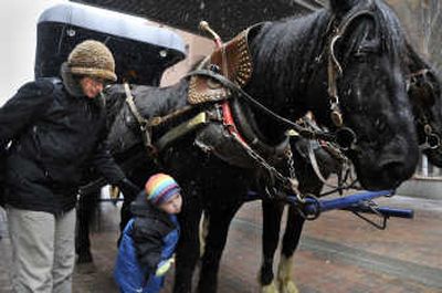 
James Kluge, of Medical Lake, gives Manly Stanley a hug after riding with his mother, Alicia, on Spencer's Carriage Rides in downtown Spokane.
 (Dan Pelle / The Spokesman-Review)