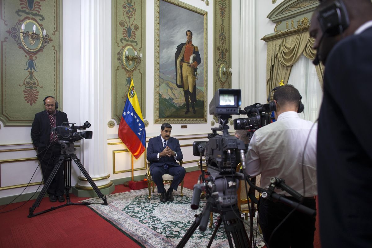 Venezuela’s President Nicolas Maduro speaks during an interview with The Associated Press at Miraflores presidential palace, where a painting of independence hero Simon Bolivar hangs, in Caracas, Venezuela, Thursday, Feb. 14, 2019. Maduro is inviting a U.S. special envoy to come to Venezuela after revealing during the interview that his foreign minister recently held secret meetings with the U.S. official in New York. (Ariana Cubillos / Associated Press)