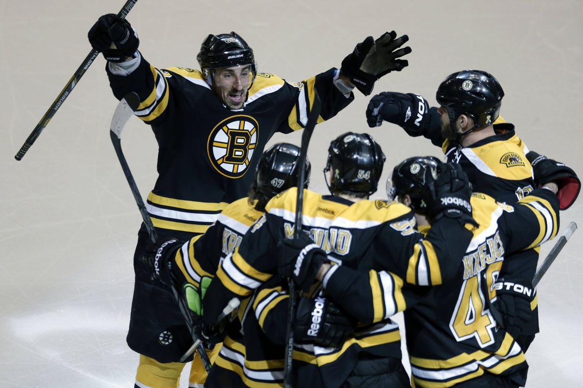 The Boston Bruins gather to celebrate after Adam McQuaid, front center, scored the lone goal of Friday’s series-clinching win. (Associated Press)