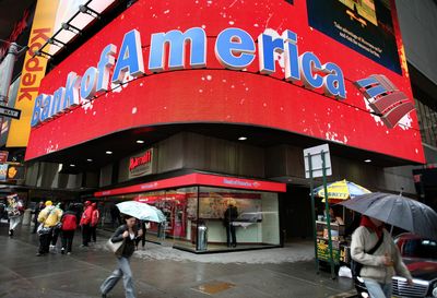 Pedestrians walk last month through New York’s Times Square under a glowing Bank of America marquee.  (Associated Press / The Spokesman-Review)