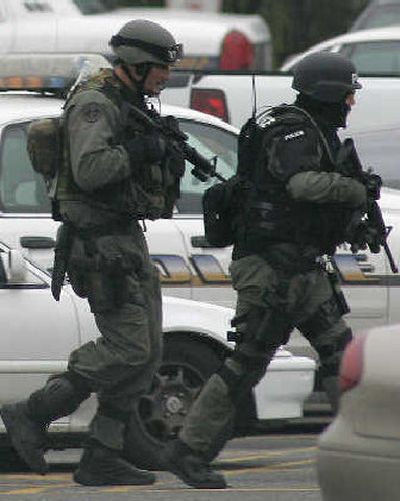 
Police SWAT team members walk through the parking lot of the Tacoma Mall, where an armed man took hostages shortly after noon on Sunday. 
 (Associated Press / The Spokesman-Review)