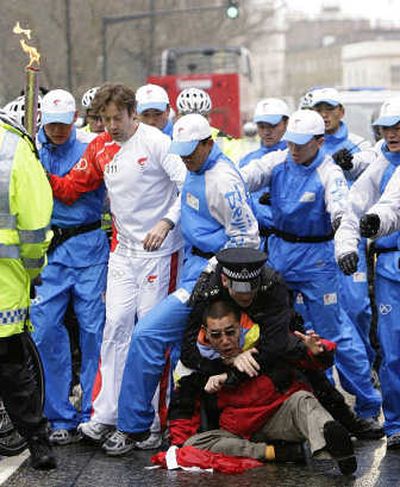 
A police officer tackles a demonstrator trying to reach the Olympic torch, at left,  in London on Sunday. Associated Press
 (Associated Press / The Spokesman-Review)