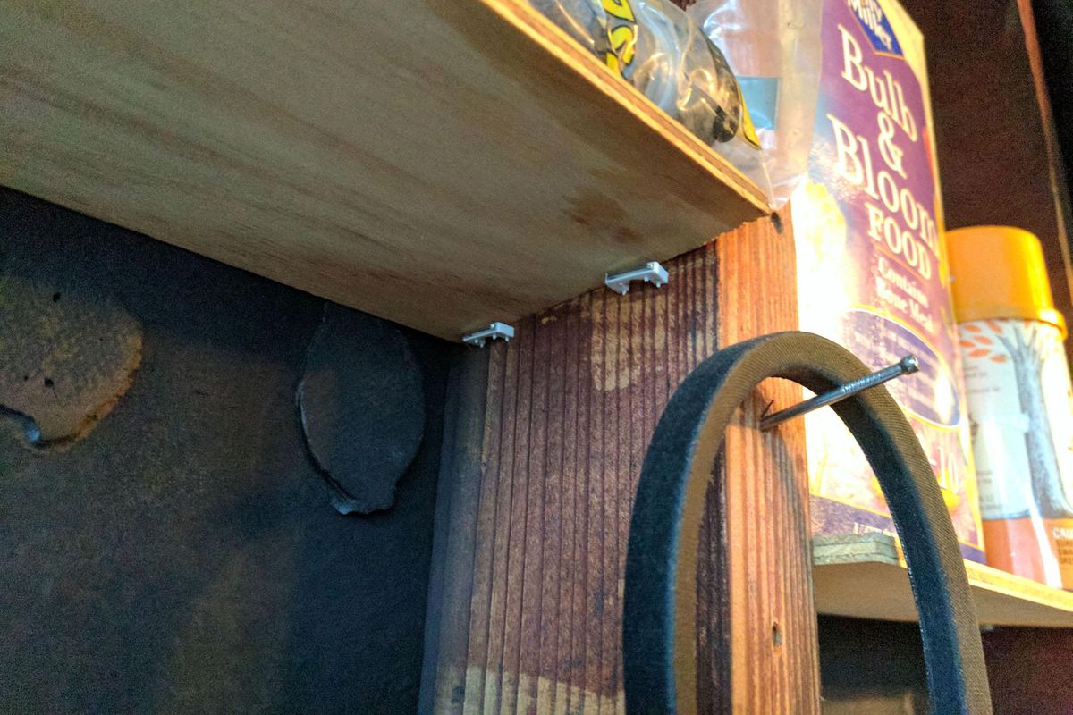 Electric cable staples driven into the wall studs are a handy way to support the ends of a shelf. (Tim Carter/Ask The Builder)