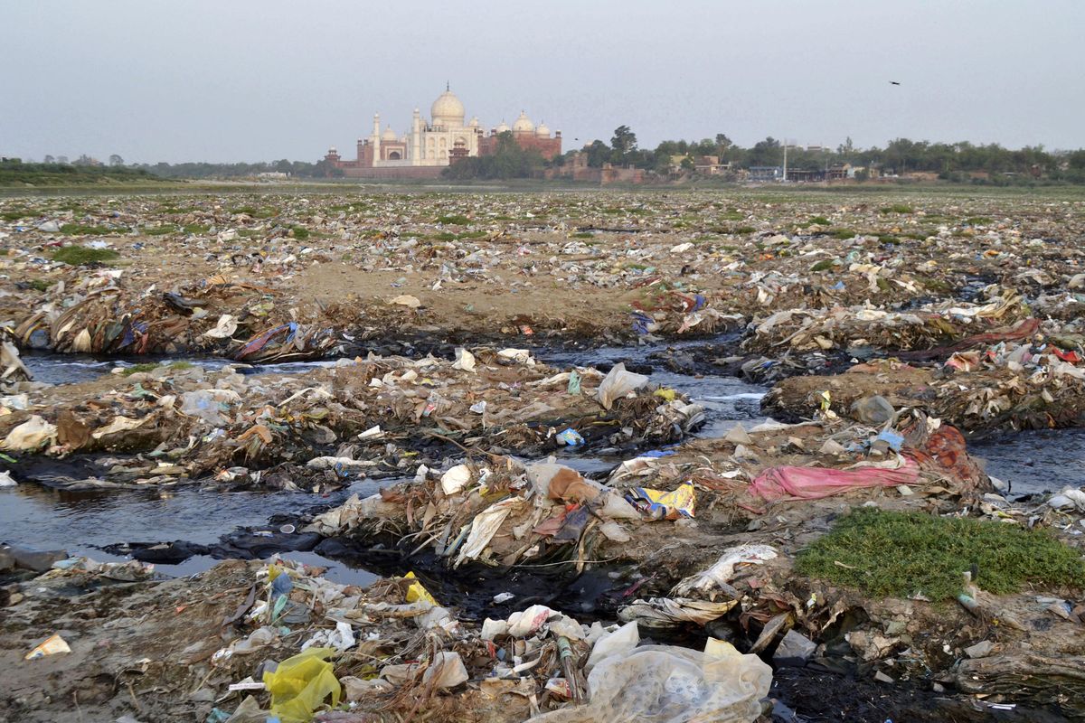 In this  May 11, 2018, photo, garbage covers the area by the Yamuna River near the Taj Mahal in Agra, India. Built by Mogul Emperor Shah Jahan for his favorite wife in the north Indian city of Agra, the Taj Mahal has been losing its sheen for years. The shining white monument to love is turning green and yellow because of air pollution and swarms of insects. 102 (Pawan Sharma / Associated Press)