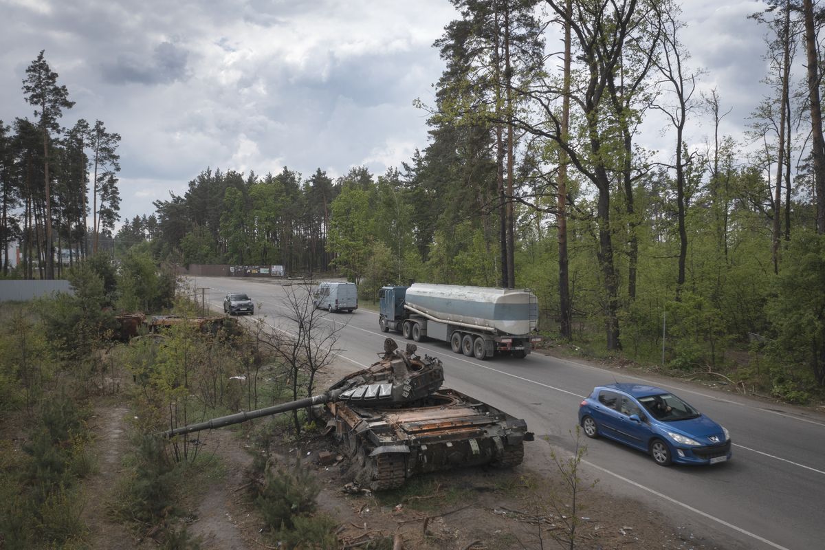 Cars pass by Russian tanks destroyed in a recent battle against Ukrainians in the village of Dmytrivka, close to Kyiv, Ukraine, Monday, May 23, 2022.  (Efrem Lukatsky)