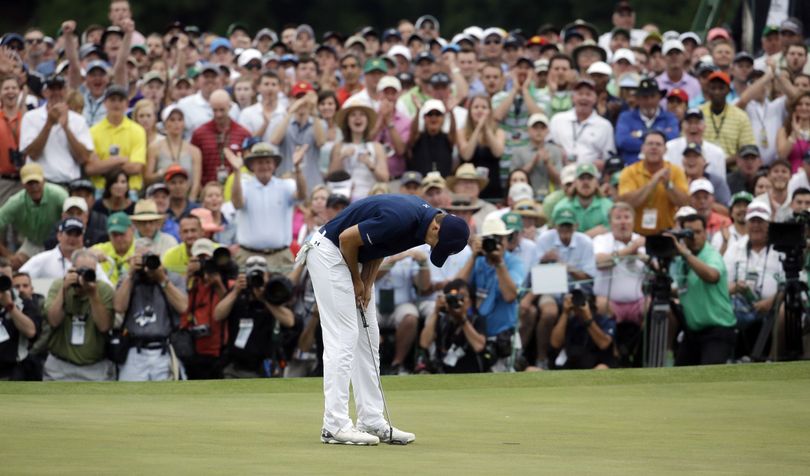Jordan Spieth bends over in relief after sinking his final putt to wrap up a four-stroke win at Augusta and become the second-youngest Masters champion after Tiger Woods. (Associated Press)