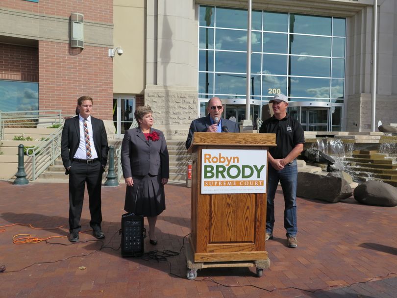 Former longtime Nampa Police Chief Curtis Homer speaks at a press conference Thursday on the steps of the Ada County Courthouse for Idaho Supreme Court candidate Robyn Brody, second from left. At left is Boise County Prosecutor Ross Pittman; at right, Owyhee County Sheriff Perry Grant. (Betsy Z. Russell)