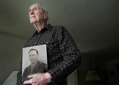 
Spokane's John Wills, now 92, was stationed in Iran during World War II to help build 1,000-mile highway and railroad links to the Soviet Union. Millions of tons of U.S. aid was transported through the Persian Corridor to Soviet troops. The photo in his hands shows the young engineer in his military uniform. 
 (CHRISTOPHER ANDERSON / The Spokesman-Review)