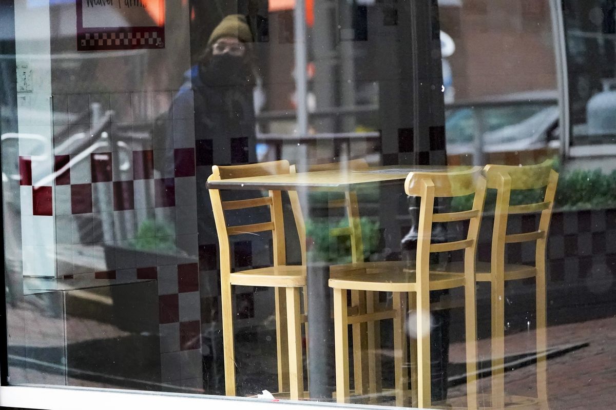 FILE - In this Jan. 17, 2021, file photo, a passerby wearing a protective mask is reflected in the window of an empty restaurant near Market Square in downtown Pittsburgh. Irritated by the sweeping use of executive orders during the COVID-19 crisis, state lawmakers around the U.S. are moving to curb the authority of governors and top health officials to impose emergency restrictions such as mask rules and business shutdowns.  (Keith Srakocic)