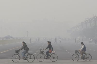 This May 1, 2008 file photo shows Chinese women cycling through smog and pollution over Beijing’s Tiananmen Square.  (File Associated Press / The Spokesman-Review)