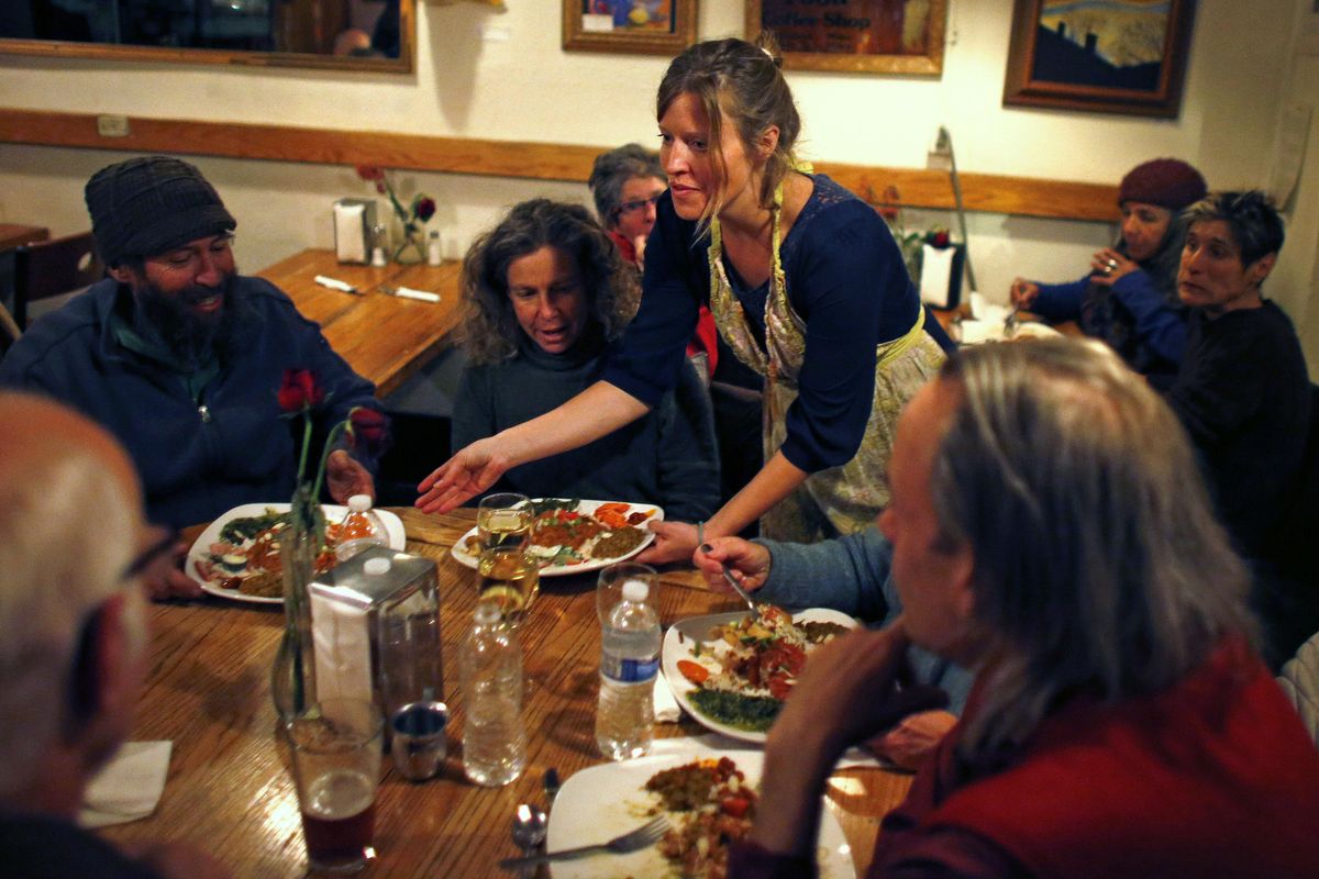 In this Nov. 23, 2013 photo, restaurant owner Rainbow Shultz delivers her own home cooked food to guests. Political divisions in the United States are being felt around the Thanksgiving dinner table, according to to a draft paper by researchers at Washington State University and UCLA. (Brennan Linsley / AP)