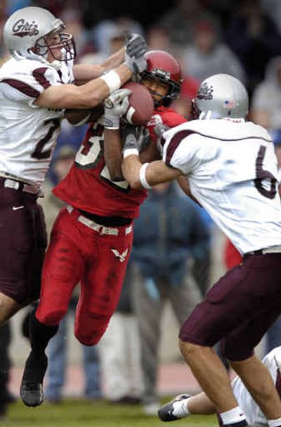 
EWU wide receiver Eric Kimble (32) hauls in a 13-yard reception over defenders Matt Lebsock, left, and Tyler Joyce. 
 (Colin Mulvany / The Spokesman-Review)
