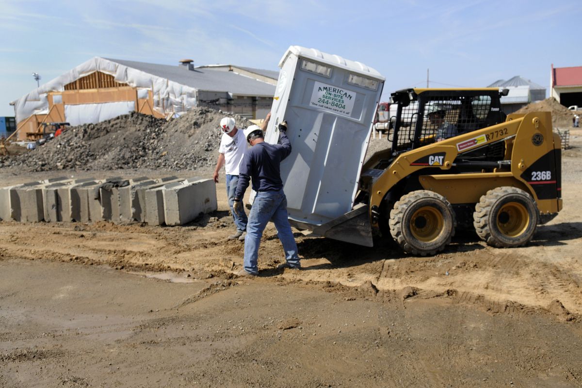 bartr@spokesman.comFreeman High School has been largely torn down and construction is under way for the modernization and addition project, and all that is left standing is the gym and multi-purpose room, while Buddy Hutton, left, and Mike McCully move a portable toilet into place on the site. (J. Bart Rayniak / The Spokesman-Review)
