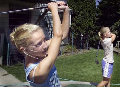 
Sierra, left, and Savana Bezdicek hit balls off the deck of their home where their father, Randy, has built a driving range. 
 (Christopher Anderson / The Spokesman-Review)
