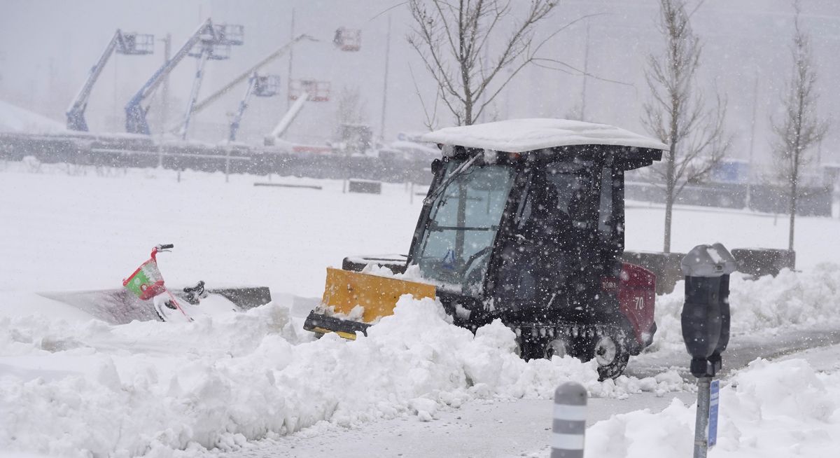 A maintenance worker uses a plow as a snowstorm rips across the intermountain West Sunday, March 14, 2021, in Denver. Forecasters are calling for the storm to leave at least another six inches of snow during the day before moving out on to the eastern plains.  (David Zalubowski)