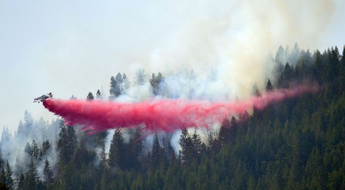 An airplane drops fire retardant on a hillside fire above Newman Lake on Monday, July 30, 2018. (Kathy Plonka / The Spokesman-Review)