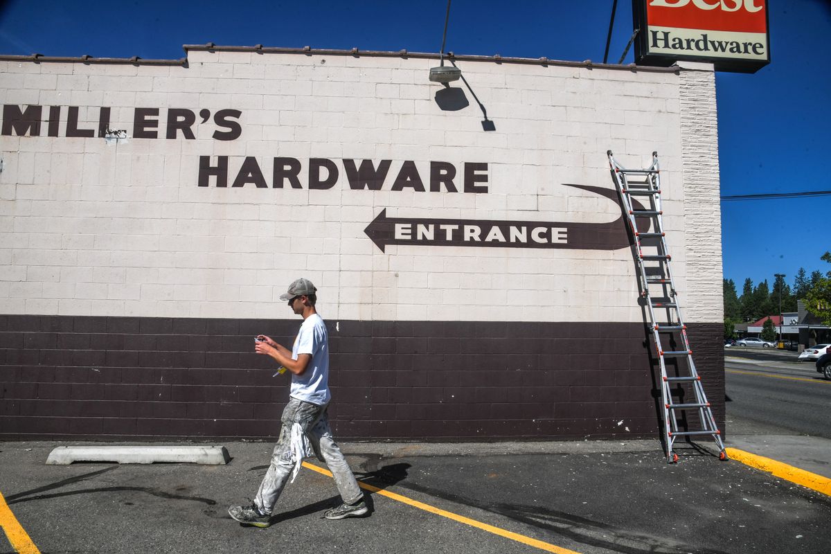 Isaac Wooley of R David Painting prepares the exterior of Miller’s Hardware for a new coat of black and white paint Friday.  (DAN PELLE/THE SPOKESMAN-REVIEW)