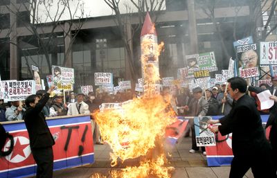 South Korean protesters burn a mock missile and North Korean flag during a rally against North Korea’s recent military policy near the U.S. Embassy in Seoul, South Korea, on Saturday.  (Associated Press / The Spokesman-Review)