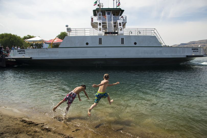 Robert Thomas, 10, left, and Drew Jackson, 10, of Keller, Wash., cool off before taking an inaugural ferry ride across Lake Roosevelt on the new ferry near Keller on Wednesday. The Sanpoil replaced the aging Martha S., which went into service in 1948. (Colin Mulvany)