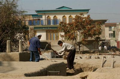 
Afghan laborers reinforce the roof of a mud house for winter next door to a mansion in the Shirpur neighborhood of Kabul. Many mud houses in Kabul have been flattened to make way for mansions. 
 (Associated Press / The Spokesman-Review)